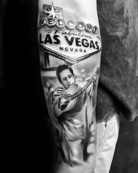 Tattoo of Johnny Cash playing guitar under Las Vegas welcome sign