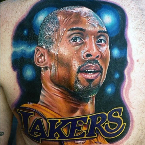 A vibrant tattoo of Kobe Bryant’s face, set against a colorful background, with the word "LAKERS" prominently featured below, capturing his iconic image.