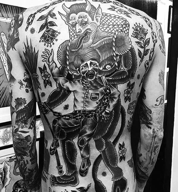 Full back Krampus tattoo in blackwork style showing the horned creature with a child in chains, surrounded by flowers and dark folklore elements.