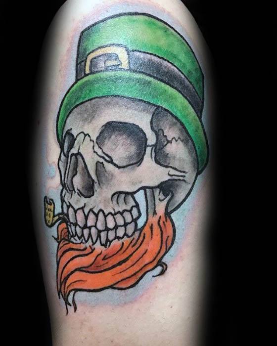 Leprechaun skull tattoo with a green hat, fiery orange beard, and a smoking pipe clutched between grinning teeth.