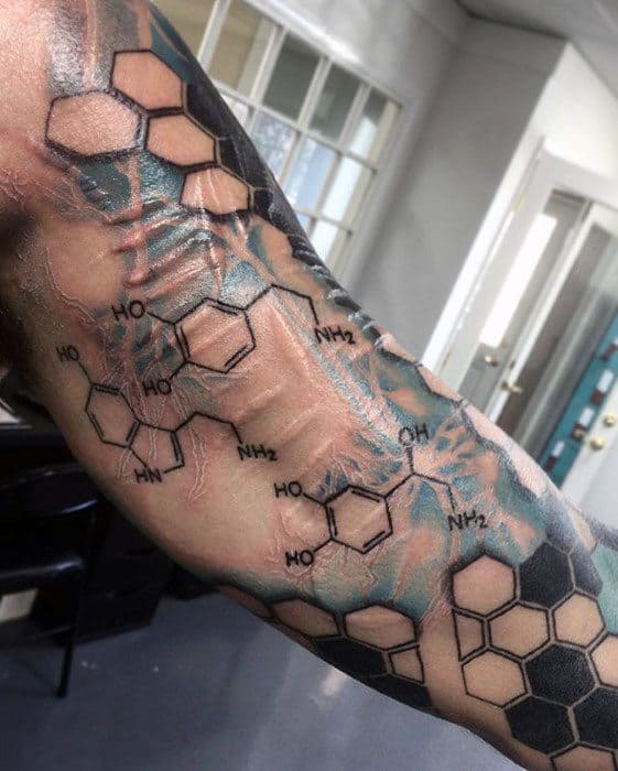 Tattoo on forearm featuring serotonin and dopamine molecular structures overlaid with honeycomb patterns and electric blue neuron details.
