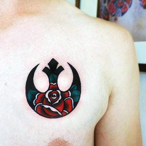 Rebel Alliance tattoo on the upper chest, featuring a red rose with green leaves in the center.