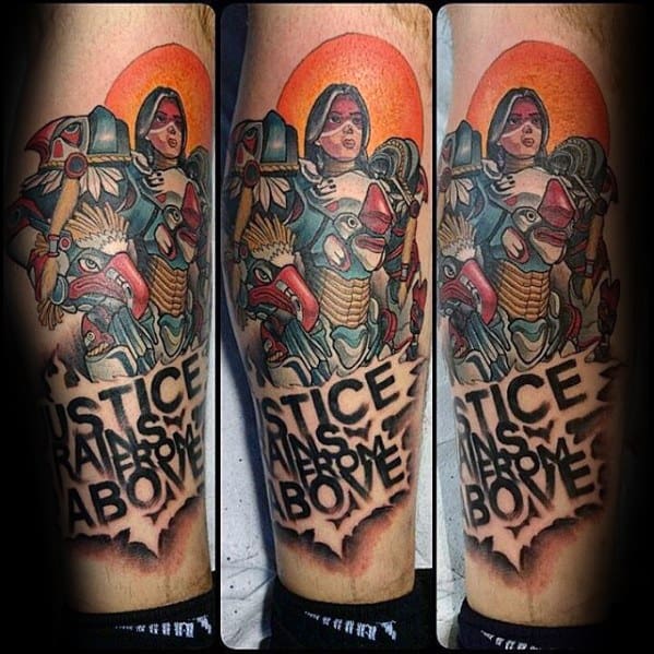 Vibrant leg tattoo of Pharah from Overwatch with her rocket launcher and the quote “Justice Rains From Above” in bold letters.