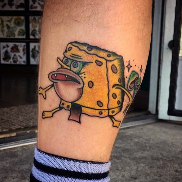 Funny distorted SpongeBob tattoo with exaggerated features, wide mouth, and sparkles on the side, giving it a surreal cartoon vibe.