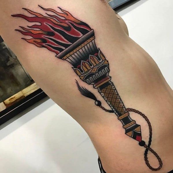 Traditional torch tattoo with bold red flames, a patterned handle, and a long rope wrapping around the arm.