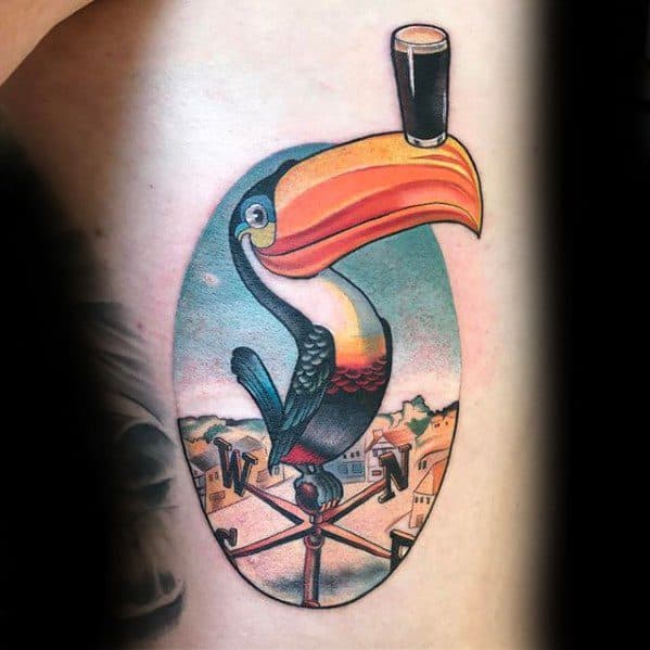 Vintage-style toucan tattoo with a pint of beer on its beak, perched on a weather vane over a colorful cityscape background.
