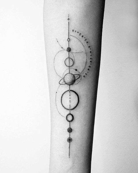 Minimalist planetary tattoo on the forearm featuring fine linework, celestial orbits, and geometric elements, symbolizing cosmic balance and exploration.