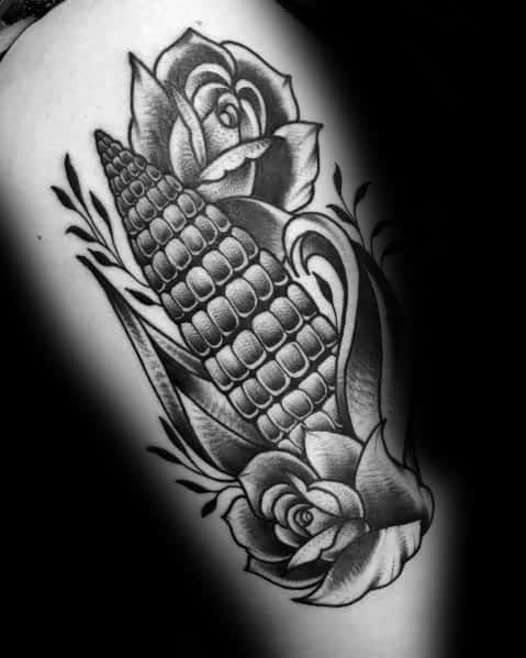 Black and gray tattoo of a detailed corn cob surrounded by blooming roses, featuring bold shading and intricate linework.