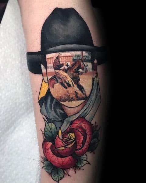 Tattoo of a cowboy hat with a faceless figure, where the face reveals a rodeo scene, surrounded by red roses, blending realism and traditional style.