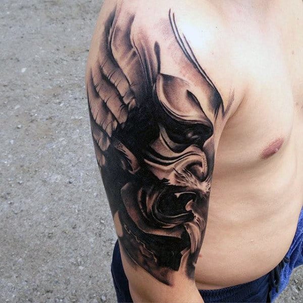 Male With Creative Tattoo Of Shaded Mask With Wings On Arm