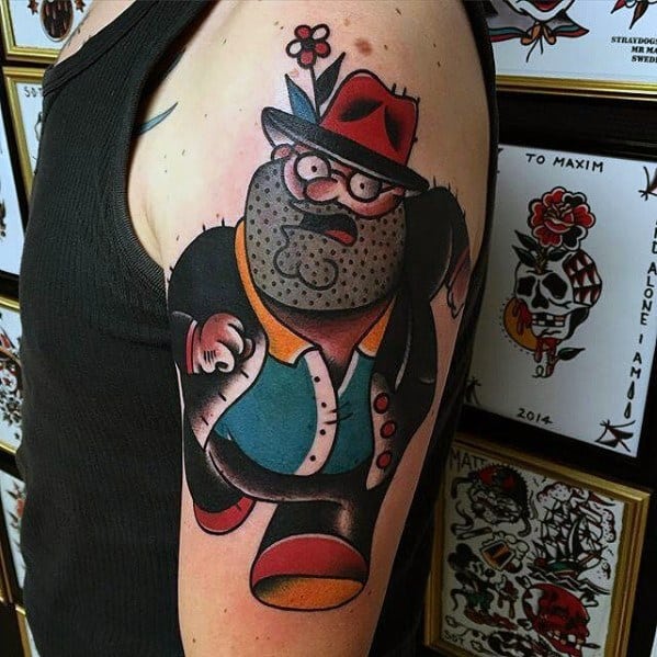 Tattoo of Peter Griffin from Family Guy in a bold, neo-traditional style, dressed as a gangster with a fedora, stubble, and a flower in his hat.