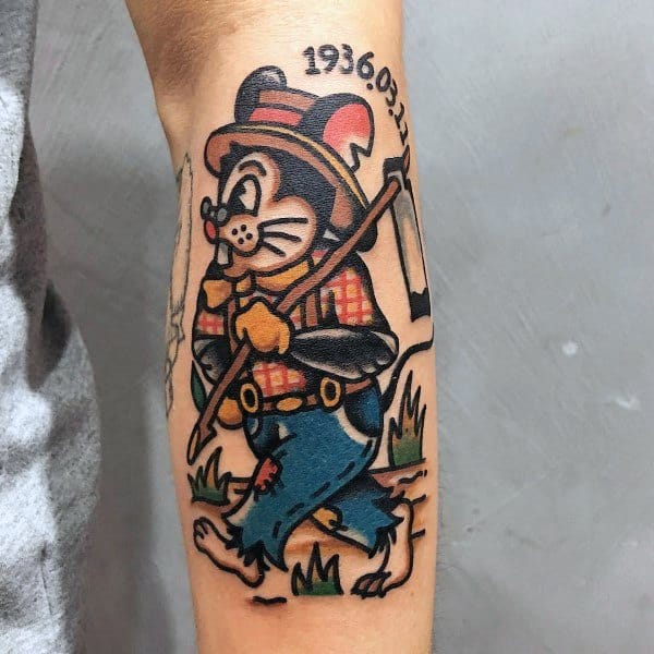 Colorful cartoon-style farming tattoo of a cheerful mouse in overalls holding a hoe, with a date inked above its head.