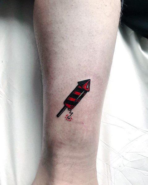 Minimalist tattoo of a small red and black striped firework rocket with a lit fuse, designed with bold outlines for a simple yet striking look.