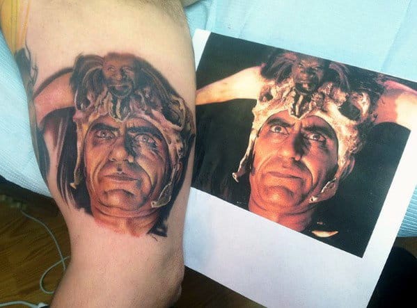 Realistic tattoo of Mola Ram from *Indiana Jones and the Temple of Doom*, featuring his iconic headdress with a skull, closely matching a reference image.