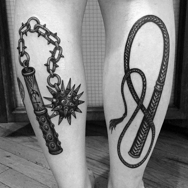 Black and gray tattoos featuring a detailed spiked mace with a chain on one leg and a coiled whip on the other, symbolizing power and control.