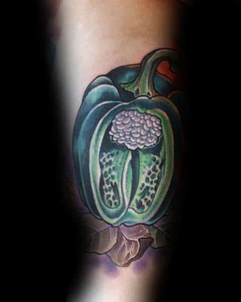 Realistic green bell pepper tattoo with a detailed cross-section, showcasing seeds and inner texture for a bold and vibrant design.