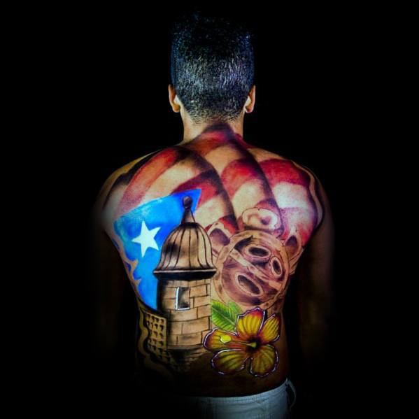 Full-back Puerto Rican flag tattoo featuring a historic garita, hibiscus flower, and cultural elements, symbolizing national pride and heritage.