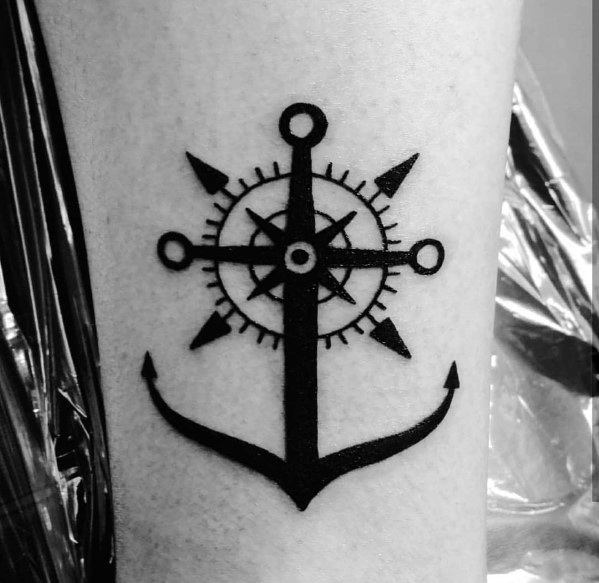 Bold black anchor and ship wheel tattoo, combining nautical symbols of stability and direction, representing guidance and a strong foundation.