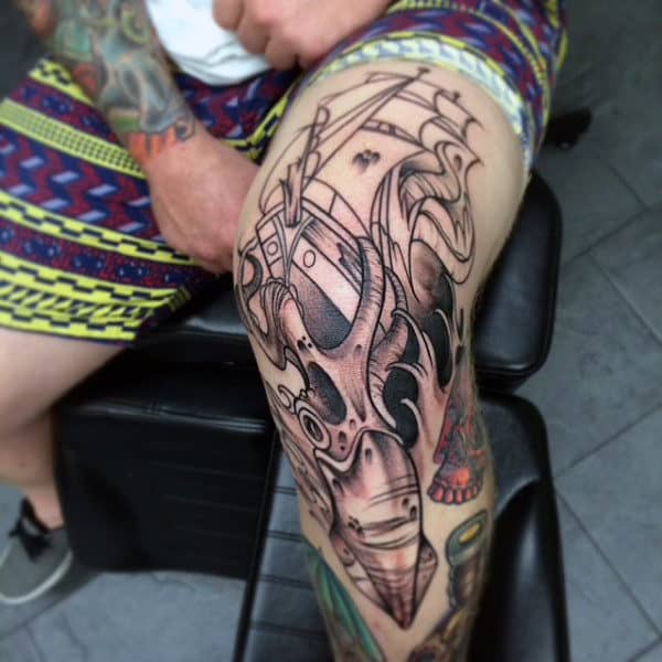 Male With Squid And Sailing Ship Knee Tattoo