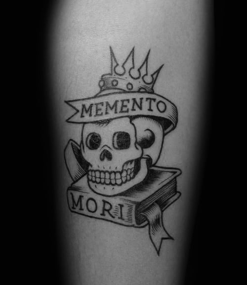 Male With Tattoo Of Memento Mori Skull And Books On Forearm