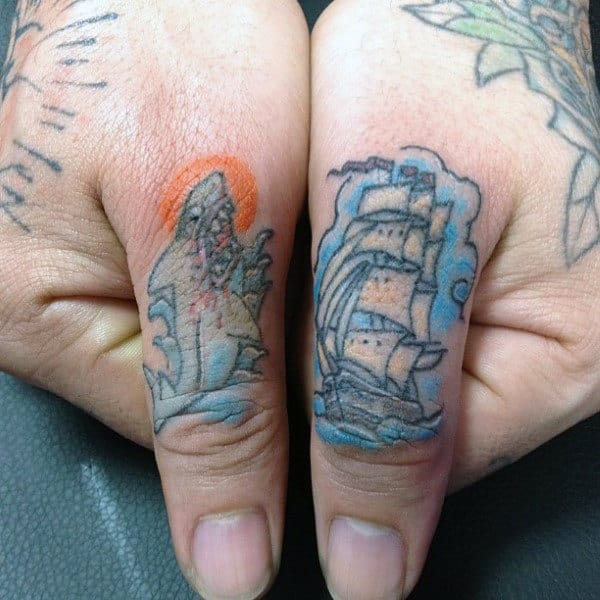 Male With Thumb Tattoos Of Shark And Sailing Ship