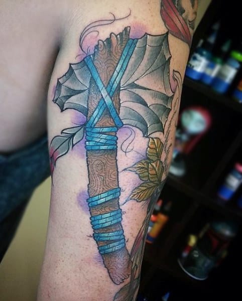 Male With Tomahawk And Blue Cord Holding Stone Axe Tattoo On Arm