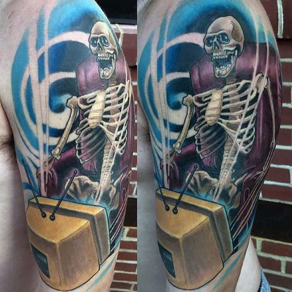Colorful tattoo of a skeleton sitting in a chair, mesmerized by a vintage TV, with swirling blue energy in the background creating a hypnotic effect.