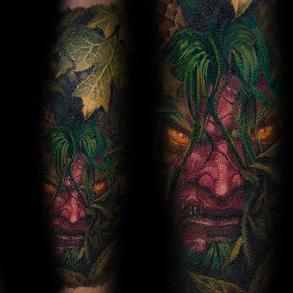 Realistic tattoo of Malfurion Stormrage from World of Warcraft, featuring glowing yellow eyes, green vines, and detailed foliage, inked with vibrant colors.