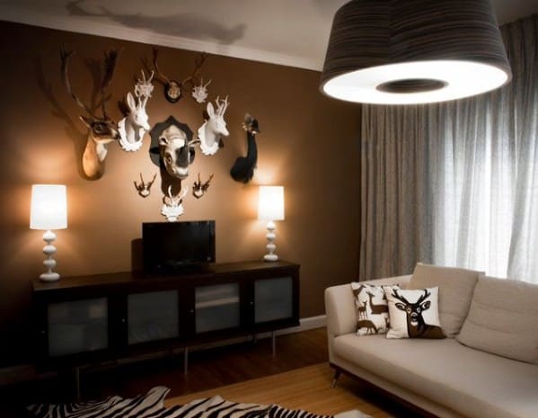 Contemporary living room featuring animal head wall decor, a white sofa, cushions, and modern lighting