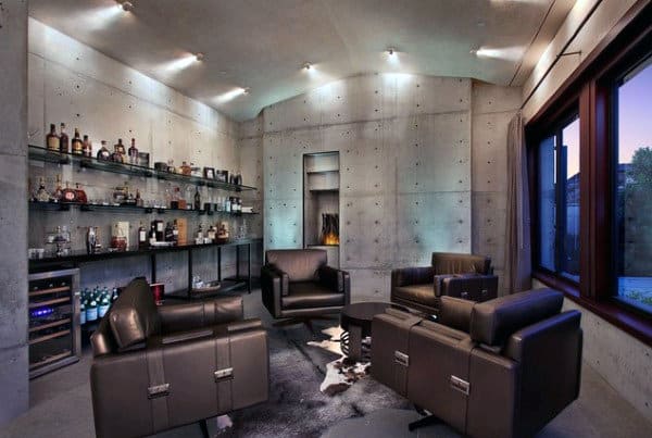 Modern bar lounge with leather chairs, shelves of bottles, a fireplace, and large window with dusk view