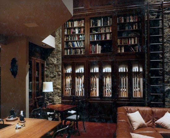 Sophisticated gun room combined with a library, featuring illuminated display cabinets, stone accents, and cozy seating.