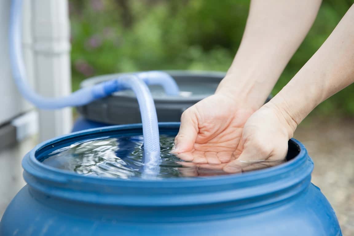 man collecting water from the rainwater for reservoir