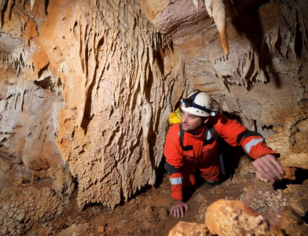 man crawling in the cave