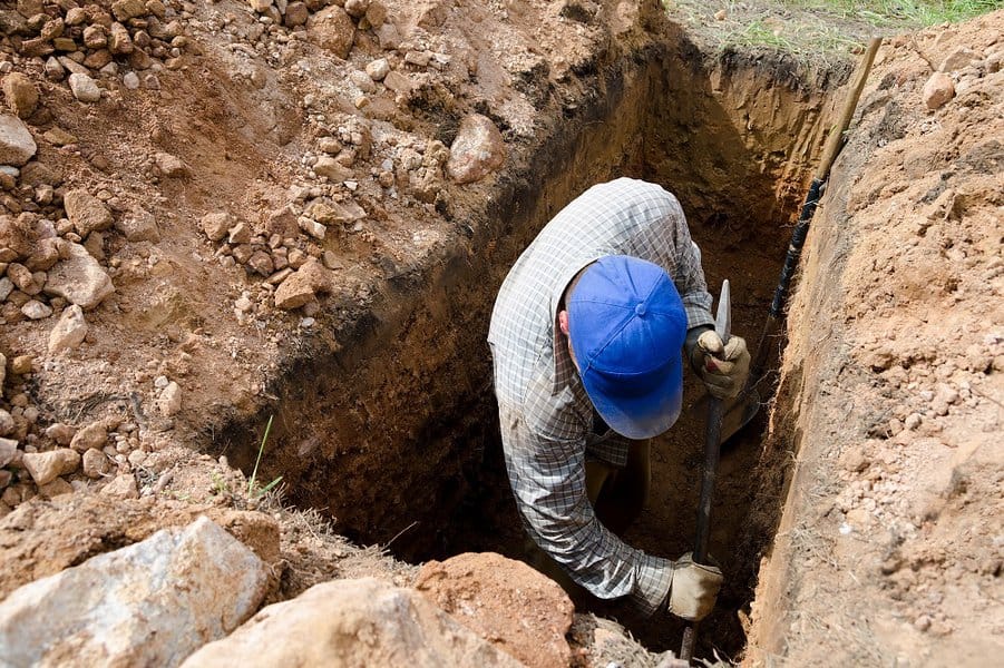 man digs grave