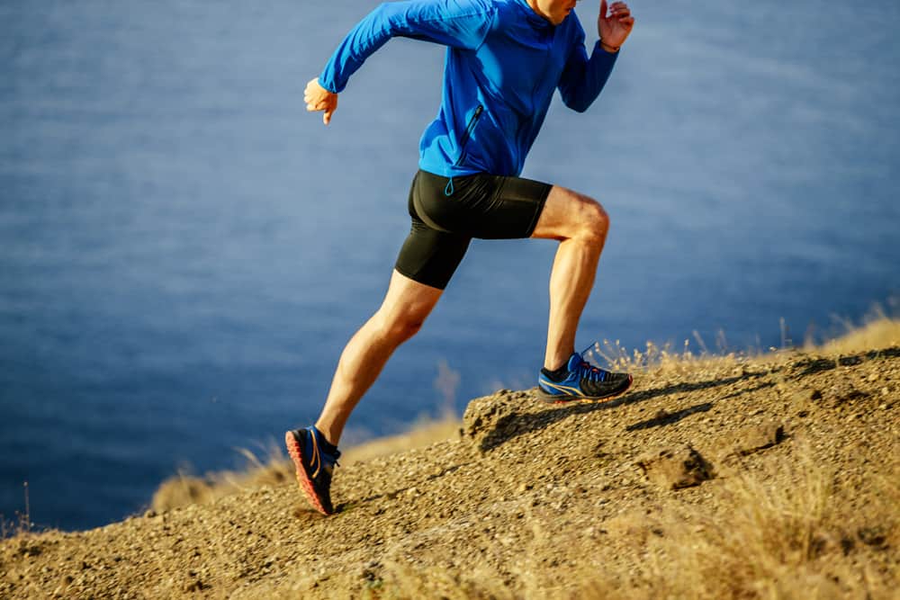 man dynamic running on steep slope of mountain