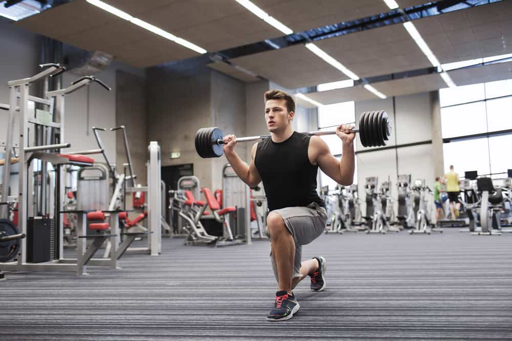young man flexing muscles in gym