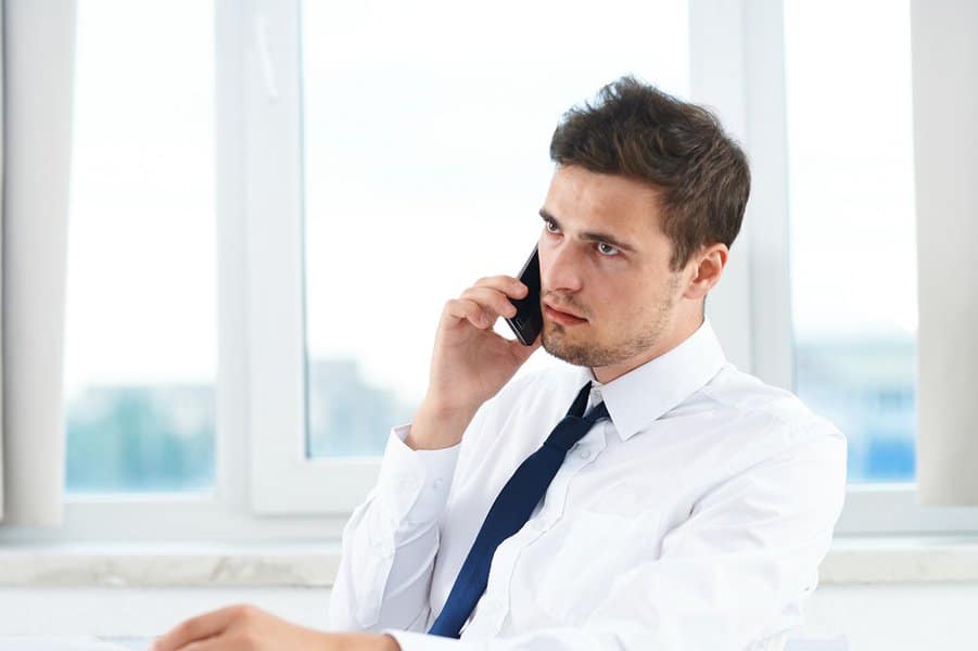 man in suit not happy while talking on the phone