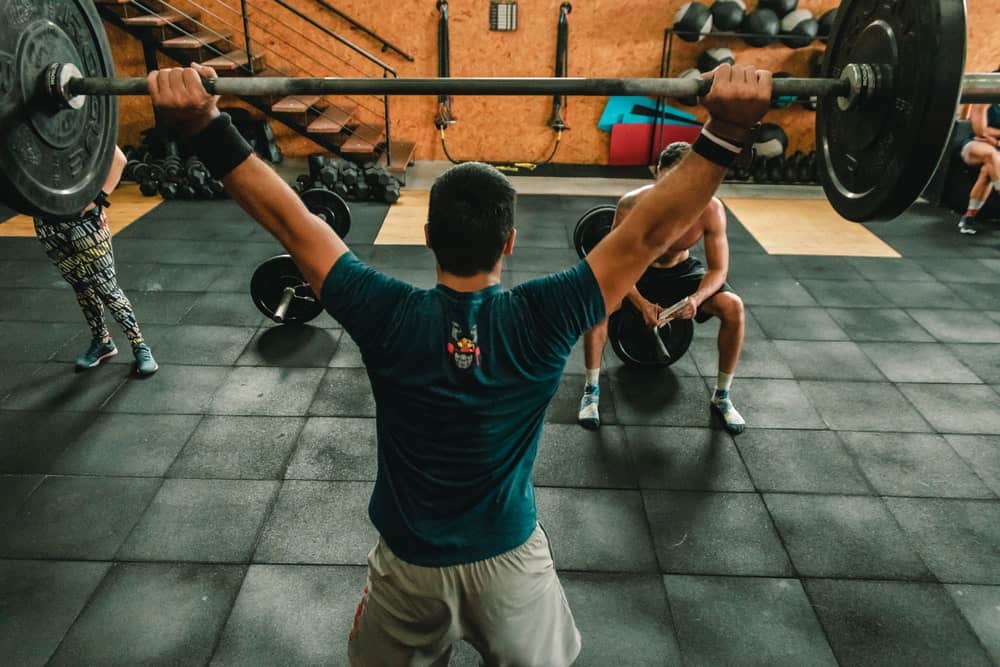 young man lifting barbell indoor gym