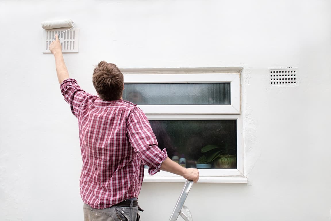 man painting the house wall