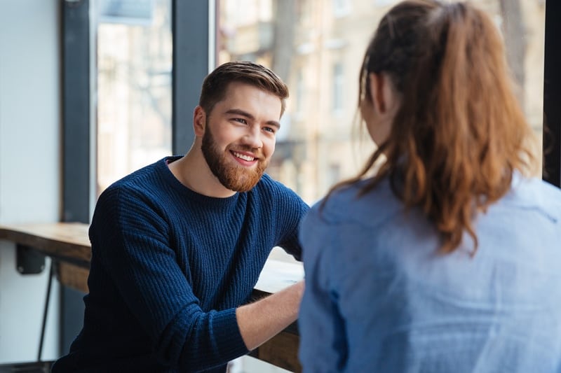 man smiling looking at her woman