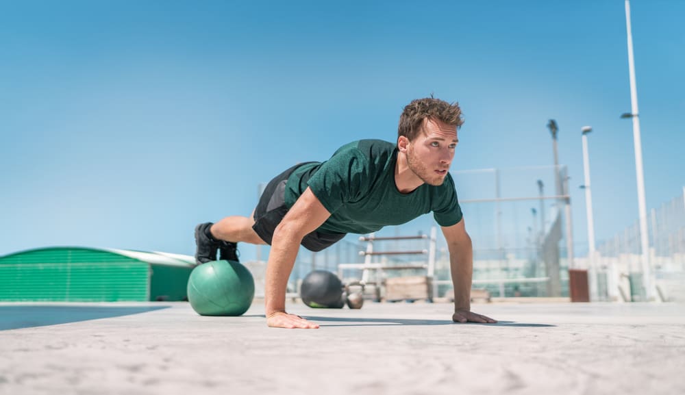 man strength training core doing decline pushup outdoor