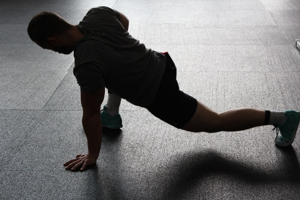 man in workout clothing stretches out his hamstrings before a workout