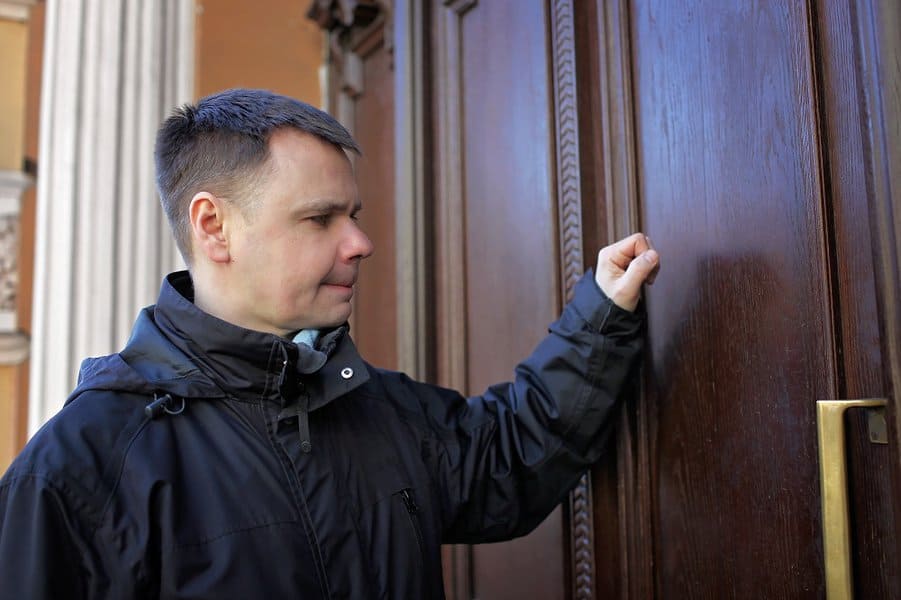 man waiting in front of house door