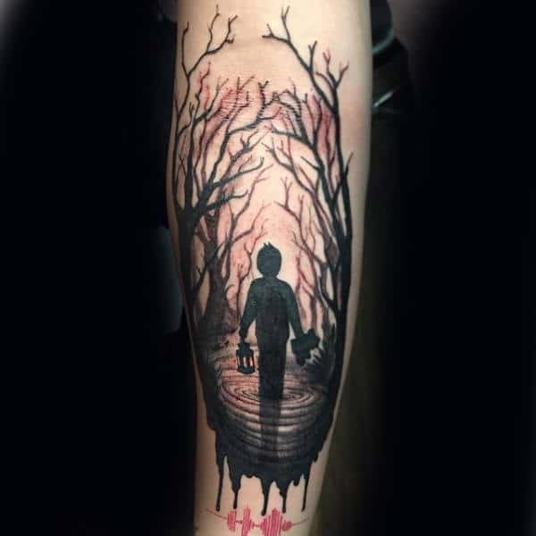 Tattoo of a silhouetted figure walking through a dark forest with bare trees