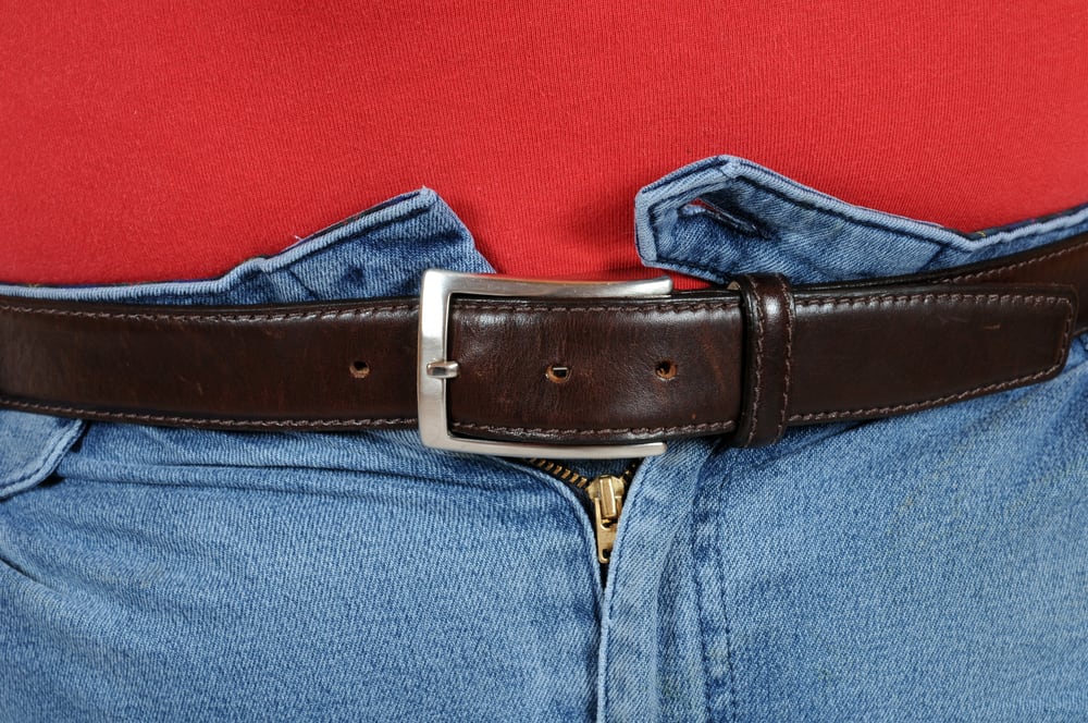 man wear belt over tight blue jeans
