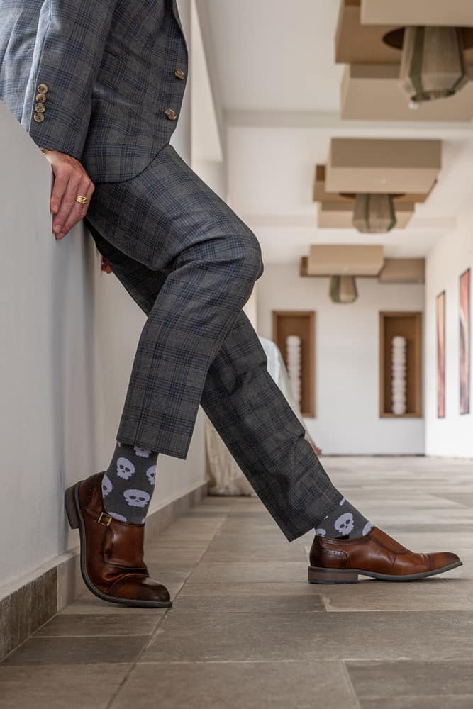 man wearing skull socks with brown shoes