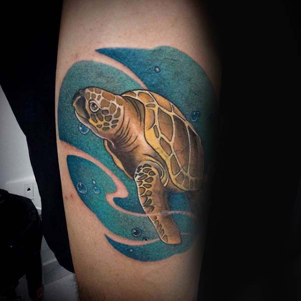 Man With Arm Tattoo Of Swimming Turtle In Blue Ink Water With Negative Space Waves