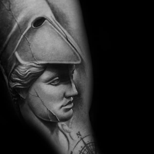 Realistic Athena tattoo styled like a cracked marble statue, with soft shading and helmet detail on the forearm