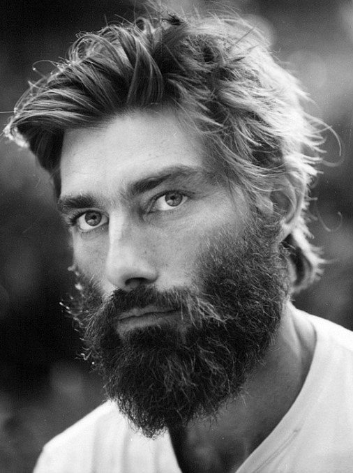 Man with tousled, medium-length hair and a full beard