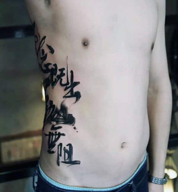 Man With Black Ink Chinese Paint Brush Stroke Writing Text Tattoo On Ribs